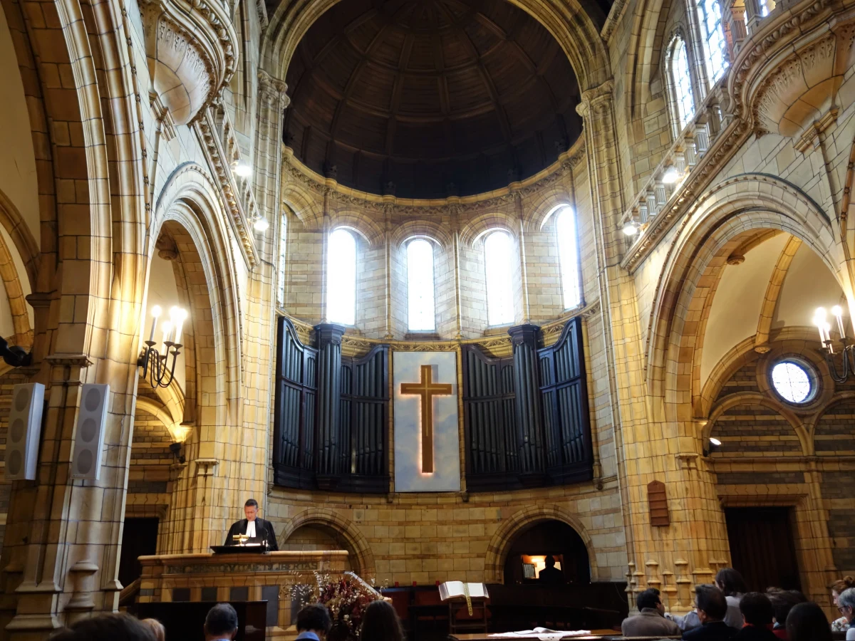Intérieur sobre d'un temple protestant avec Bible ouverte sur la chaire, lumière naturelle.