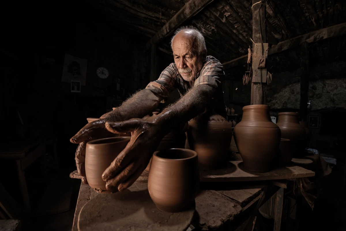 Artisan potier façonnant l'argile à la main, image de l'incarnation et de la limite technique au service d'un humain créé.