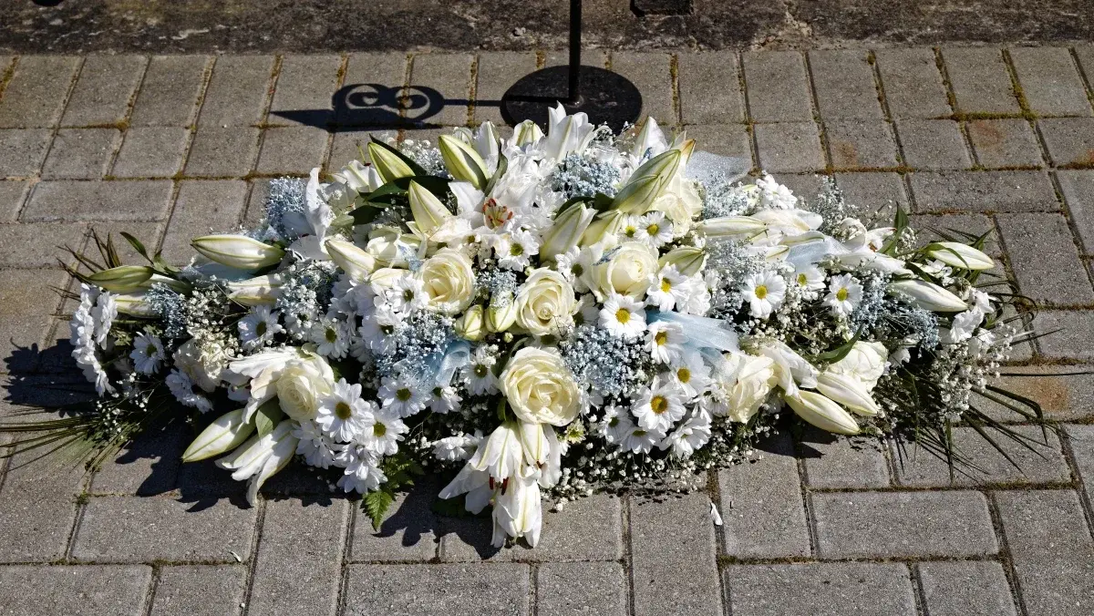 Bouquet de fleurs blanches dans un vase sobre, symbole de deuil protestant