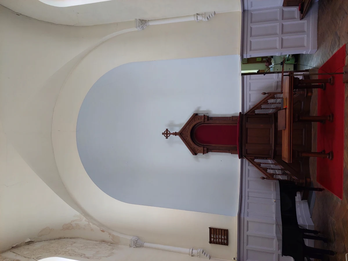 Intérieur d'un temple réformé français, sobre et centré sur la chaire