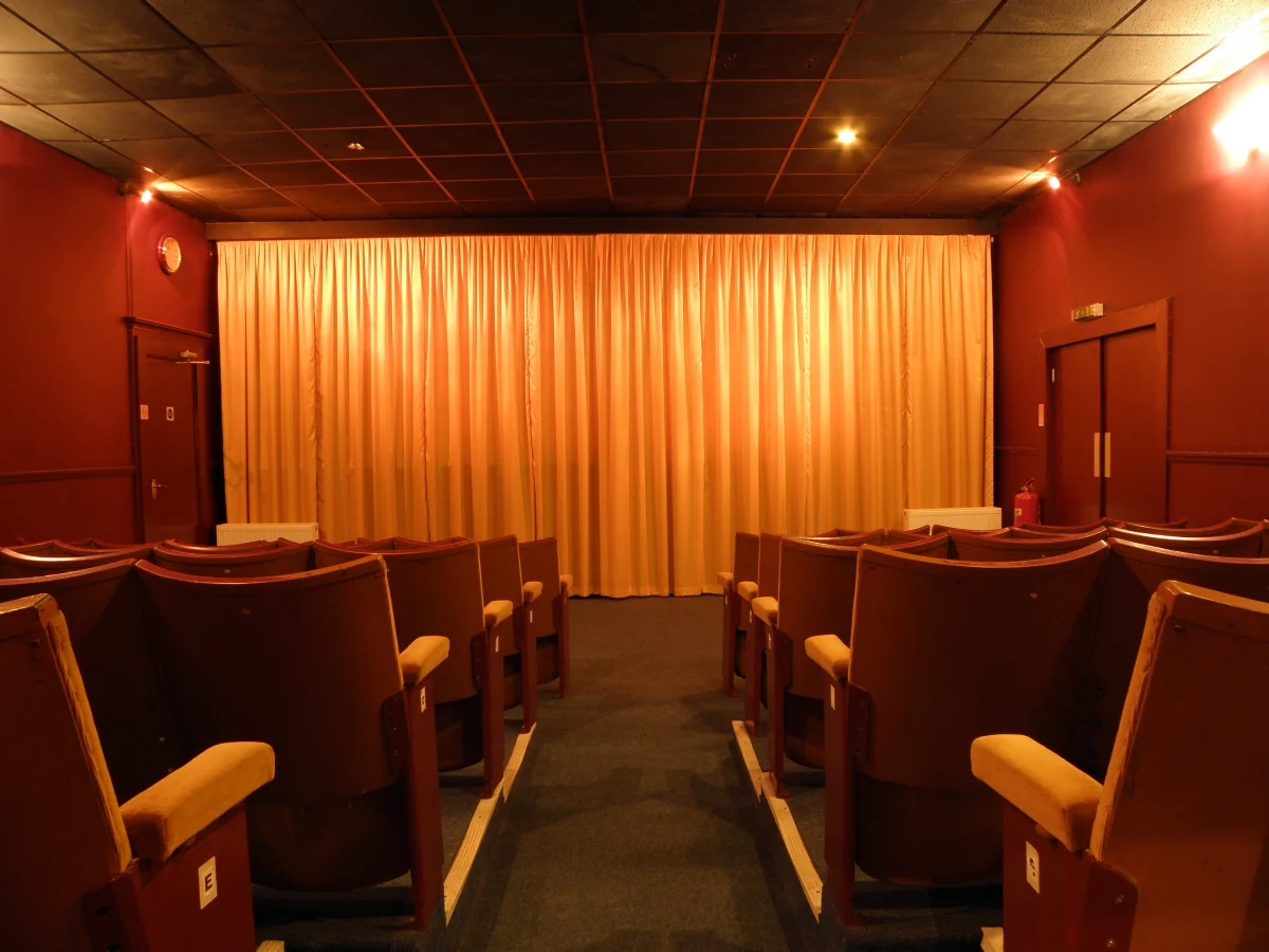 Salle préparée pour un ciné-débat en paroisse, chaises en cercle devant un écran
