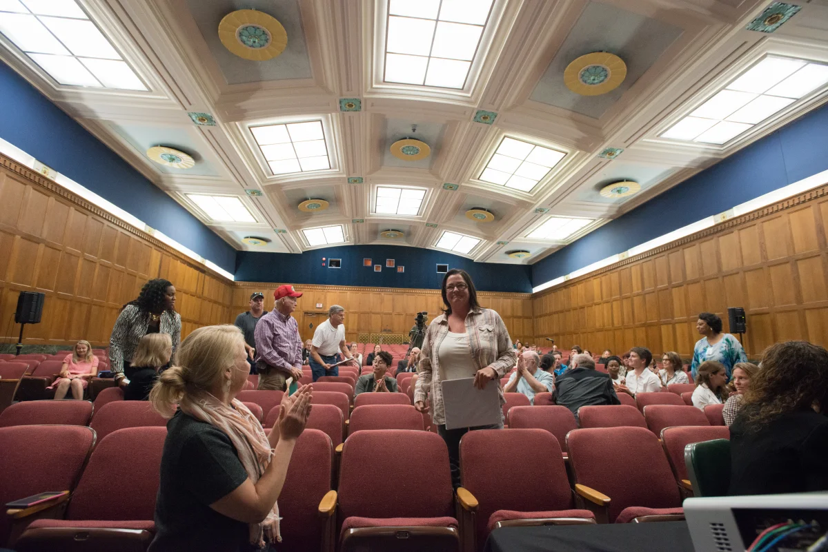 Groupe en discussion après une projection, cercle de chaises sobres.